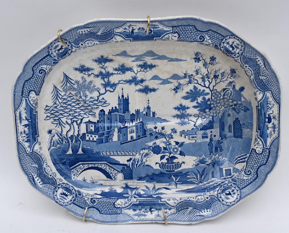 Early English Ironstone Platter: Blue and white ironestone turkey platter. Decorated with figures in a castle garden setting in the Canton style; 3in.H. x 20in.L. x 16in.W.