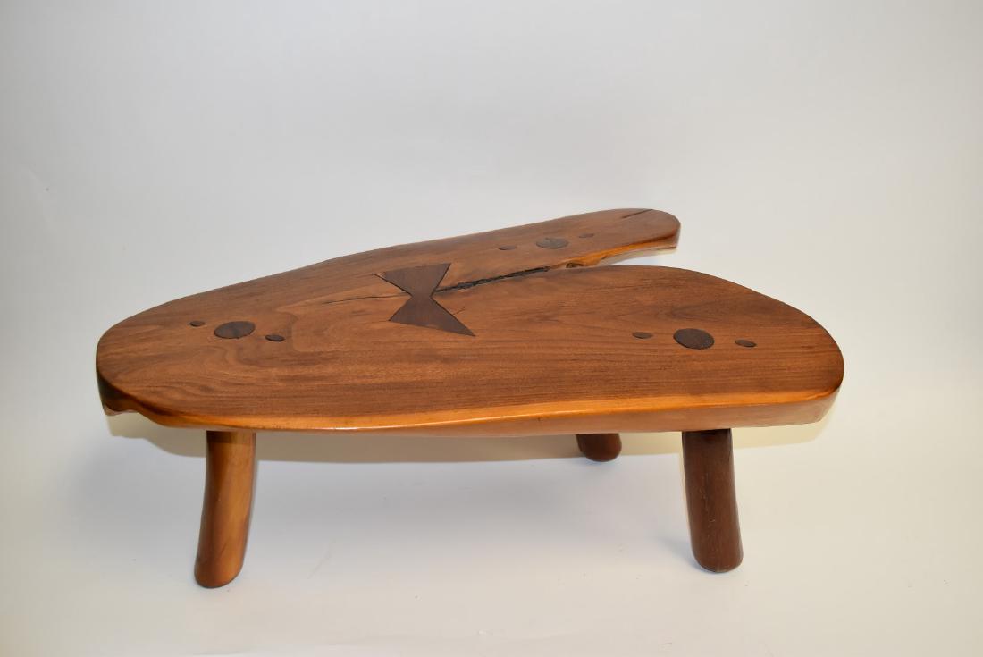 George Nakashima(after); Modernist Low Wood Table: Hand hewn low wood table. Tri-legged. Abstract form. Having original label at underside reads, Hecho En Santa Maria Guido Morellia, Mich. Mexico; 12in.H. x 27in.W. x 17in.D.