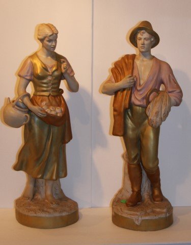 Pair of Royal Dux Porcelain Figures: Pair of hand painted porcelain figures. Man and woman farmers. Marked at underside; 20.5in. H. x 6.75in. W.