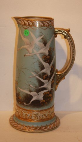 Nippon Porcelain Pitcher: Hand painted and enameled porcelain pitcher. Decorated with swans and gilt trim. Marked at the underside; 13.5in. H. x 7.5in. W.