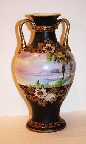 Nippon Porcelain Vase: Hand painted double handled vase. Painted landscape center panel. Marked at the underside; 11.25in. H. x 5in. W.