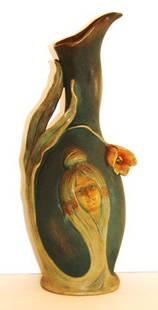 Austrian Art Nouveau Pottery Portrait Vase: Art Nouveau pottery vase. Decorated with flowers and portrait of young girl in high relief. Indiscernible mark at the underside; 12in. H. x 5in. W.