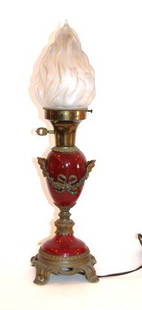 Neo Classical Porcelain and Brass Mounted Lamp: Porcelain and brass mounted boudoir lamp. Satin glass flame shade. Decorated with Bacchus heads and ribbon accents; 20.5in. H. x 5.25in D.