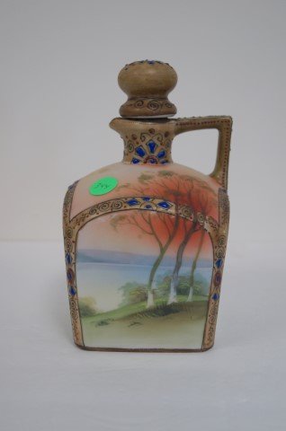 Nippon Porcelain Decanter: Hand painted porcelain decanter. Scenic lake view. Enameled trim. Marked at the underside; 7.5in. H. x 4.5in. W.