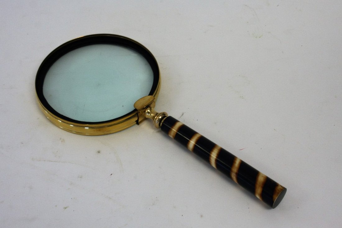 Brass Magnifying Glass: Brass framed magnifying glass.Bakelite type handle; 13.5in. L. x 6in.D.