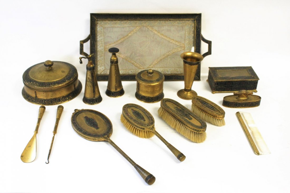 Apollo Studios 15 Piece Dresser Set: Gilt metal and enameled decoration. Comprised of glass dresser tray, dresser boxes(one with glass insert), brushes, combs, hand mirror, atomizers, etc. Marked Apollo Studios New York and numbered ; 3.