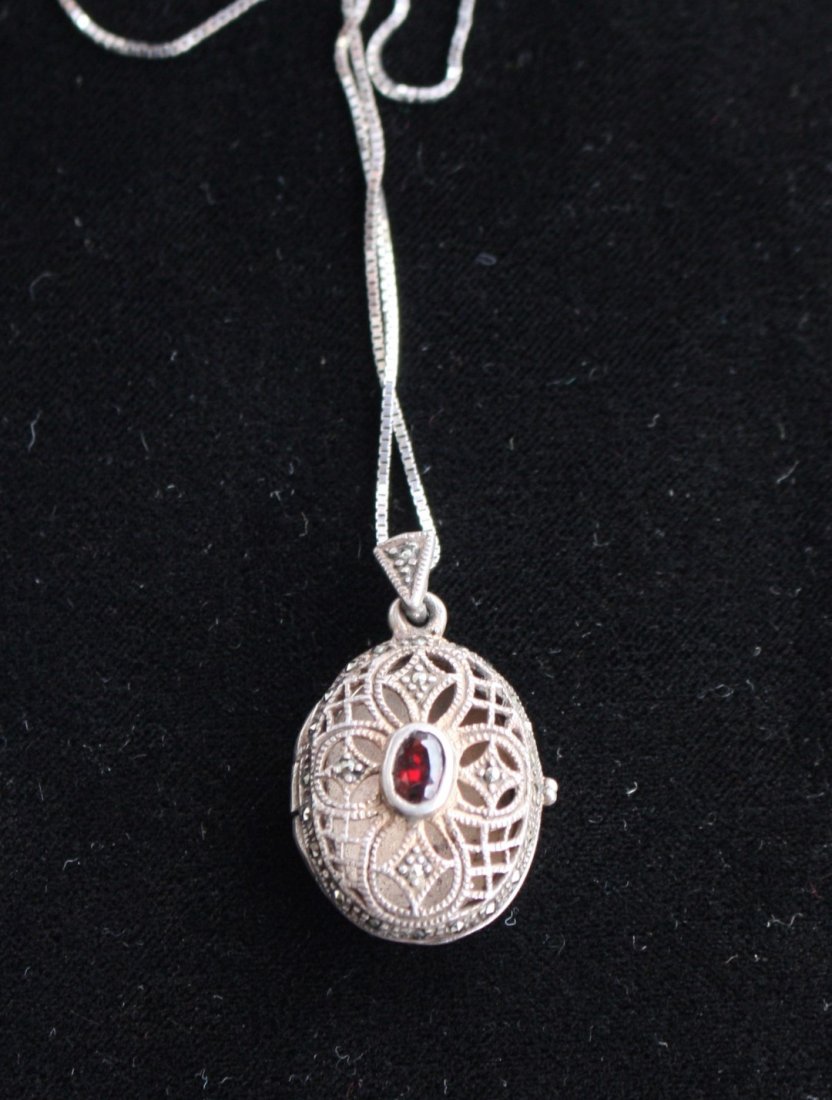 Sterling Art Deco Filigree Locket With Garnet: Art Deco filigree sterling silver locket with garnet. Size: 1.25 in. x .75 in.