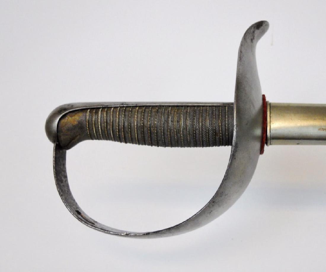 Spanish Cavalry Sword, 1874 Date: 19th C. Spanish Cavalry sword. Steel cup hilt with wire wrapped shagreen grip. Curved steel blade marked, "FcaDE TOLEDO". Steel scabbard with one suspension ring. Blade measures 30.25". Blade overall 