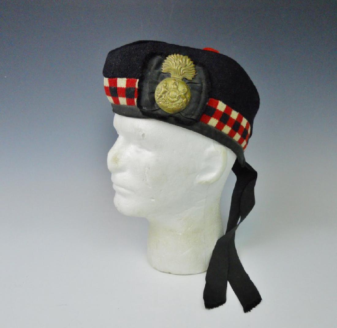 WW1 Royal Scots Fusiliers Side Cap: WW1 Original Royal Scots Fusiliers side cap. Wool construction with checkered border and brass Scots Royal Fusiliers badge attached to ribbon. Cap with red pompom and black silk tally. Interior lining