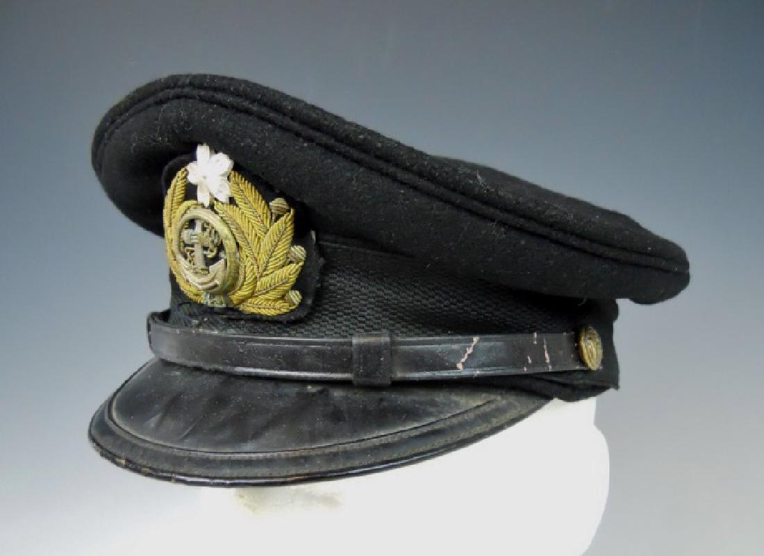 WW2 Japanese M1905 Imperial Navy Officer Visor Cap: WW2 Original M1905 Japanese navy officer visor cap. Wool construction with leather visor and chinstrap, secured by gilt metal pins with fouled anchor and compass. Insignia of encircled fouled anchor i