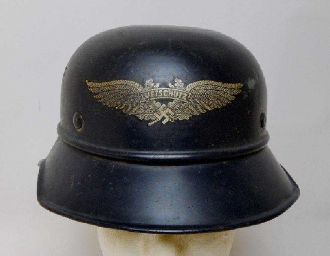 WW2 German Luftschutz Helmet: WW2 Original Luftschutz Helmet with decal. Gladiator style helmet with blue painted surfaces with winged swastika "Luftschutz" decal. Interior with leather liner and chinstrap. Partial white decal on 