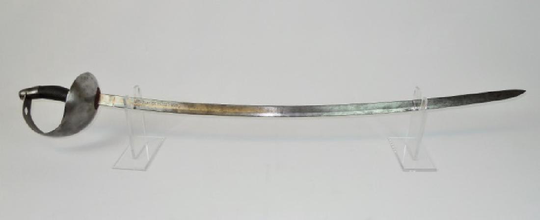 Spanish M1895 Cavalry Sword, Toledo 1899: Spanish M1825 Cavalry sword. Steel cup hilt with curved checked grip. Curved steel blade, signed "ARTa FABa De TOLEDO 1899". Sword blade measures 30.5."