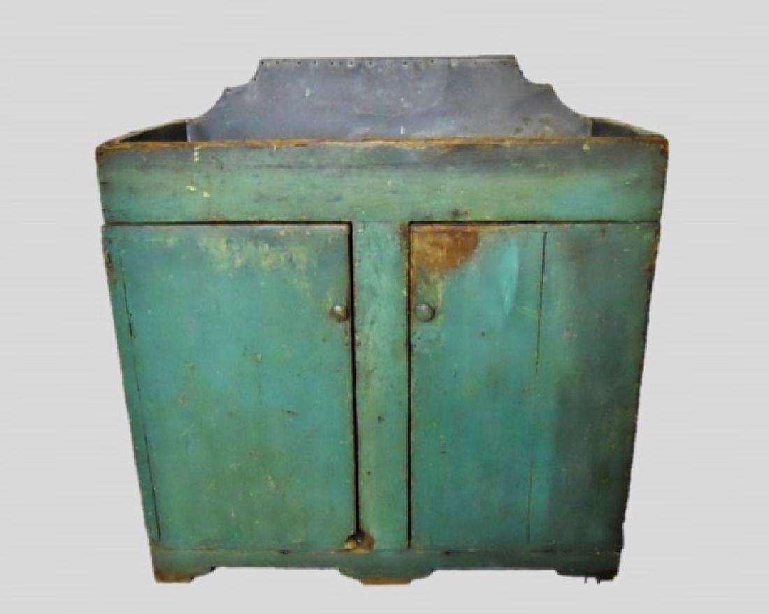 19th C. New England Dry Sink in Old Paint: Primitive dry sink with zinc lined top and two drawer cabinet. Metal nailed to frame at top, interior cabinet with shelf, bracket carved base and board back. Surfaces in period blue paint with wear an