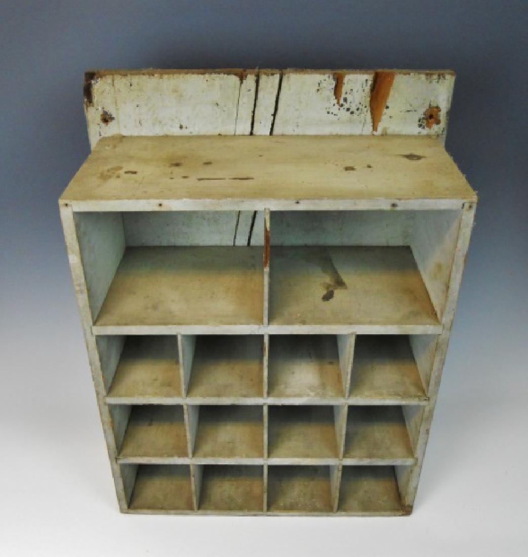 19th C. Hanging Wall Cabinet in Old Paint: Primitive hanging wall box with fourteen open cubby holes. Cabinet with old grey painted surfaces. Measures: 24" H x 18.75" W x 8.75" D