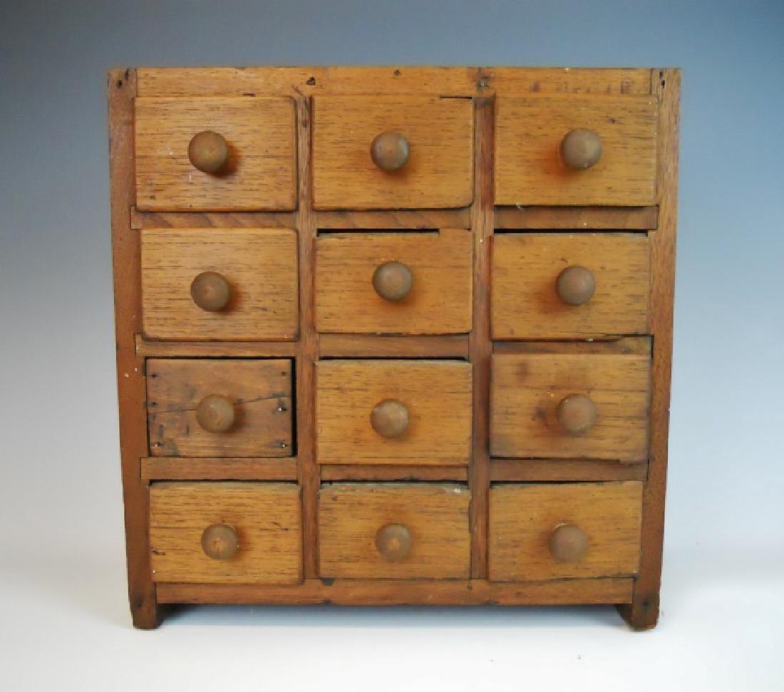 19th C. Spice Cabinet with 12 Drawers: Primitive spice chest, cabinet constructed in pine and hickory wood, with twelve drawers. Backboard missing, replaced drawer. Cabinet measures 15 1/4" H x 14 3/4"W x 6" D.