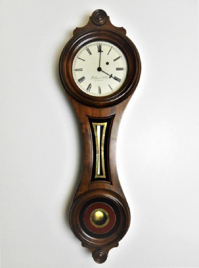 Walnut Figure Eight Wall Clock, E. Howard, Boston: Walnut figure eight cased 8- Day Brass weight driven wall clock with Roman numeral radial dial with blackened steel hour and minute indicator hands, signed, " E. Howard & Co., Boston" Case glazed, rev
