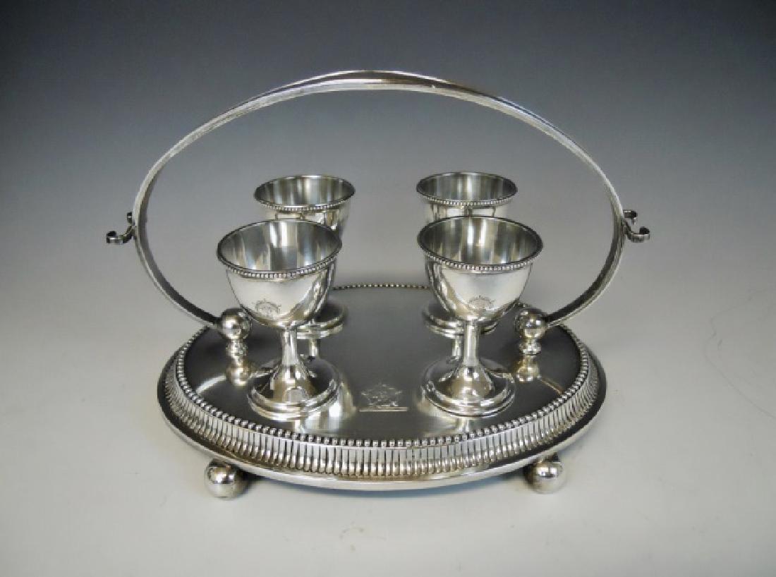 Victorian Silver Egg Cup Set Charles Boynton 1889: Five piece sterling silver egg cup cruet set, bearing "CB" Charles Boynton touchmark, with London and 1889 hallmarks. Oval tray with gadrooned edge on ball feet with four tapered goblet form egg cups