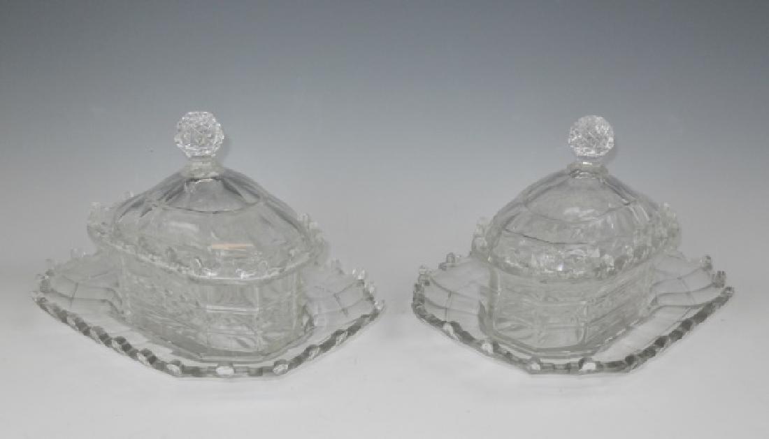 19th C. English Cut Glass Covered Dishes (2pc): Pair of 19th C. George III style cut glass covered serving dishes. Three piece consisting of base, bowl and cover with faceted cut pattern and pagoda style form with dentil borders and faceted finial.
