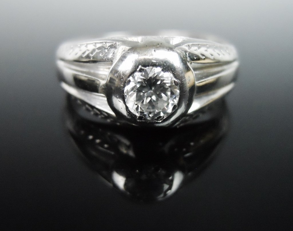 18K Gold and Diamond Ring, .55 ct: Men's ring crafted in 18K white gold with hand chased embellishment, set with a .55 ct round modern brilliant cut diamond independently graded as VS2 clarity and G color. Ring sized 11, setting is 7 g