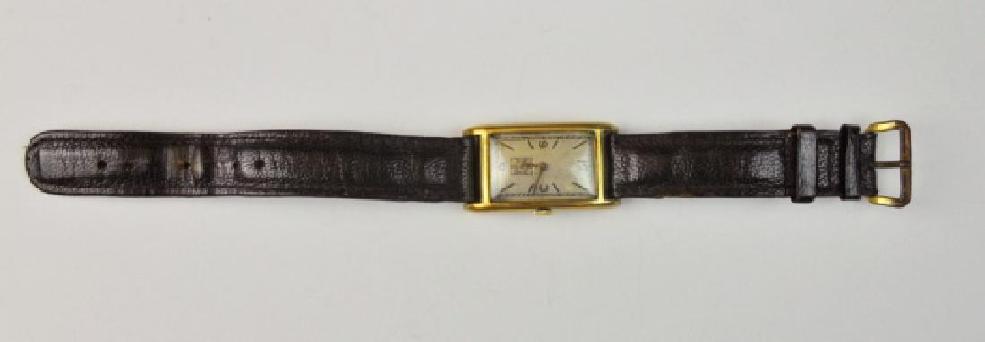 1930's Men's 14K Gold Swiss Tank Watch, Movado: Men's 14K gold tank watch, MOVADO. Silver face with Arabic numeral numeral radial dial with gilt hour and minute indicator hands, with seconds. Works signed, "MOVADO FACTORIES SWISS MADE 4 ADJ 15 JEWE