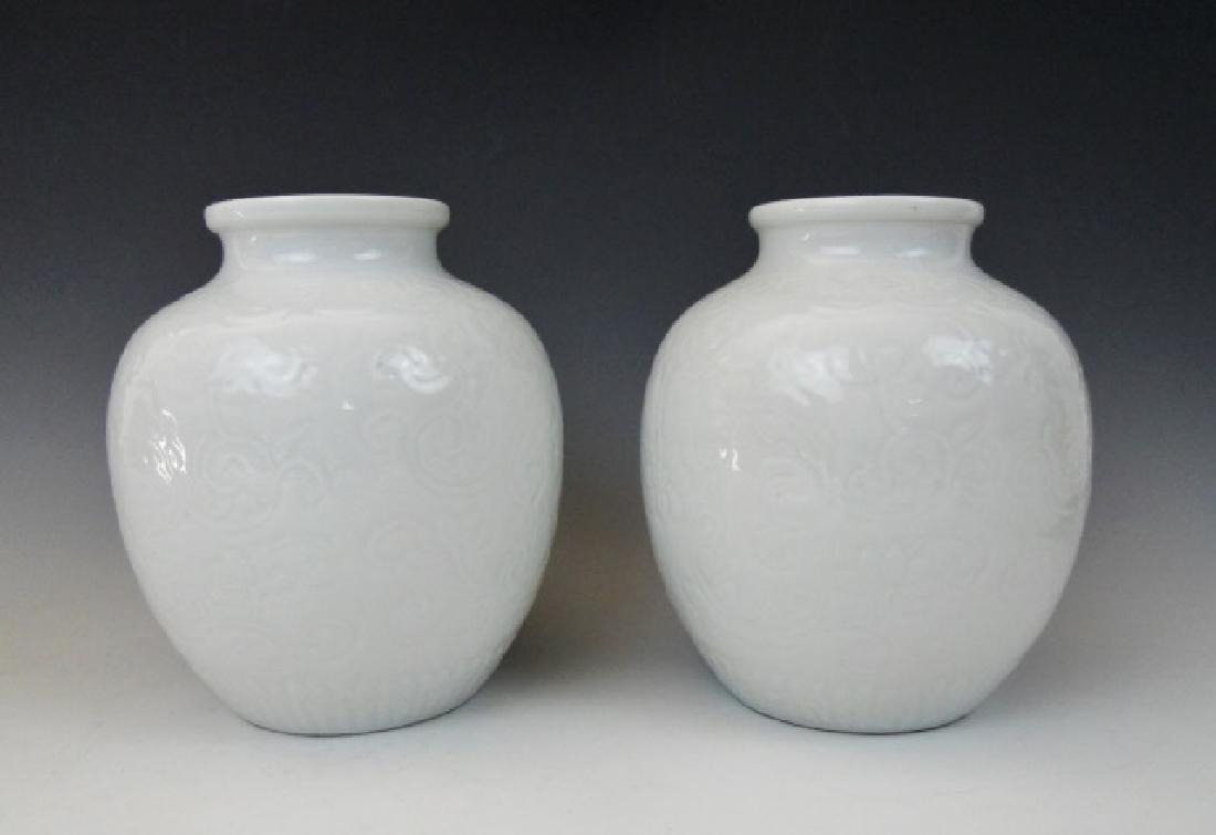 Pair of 19th C. Chinese Chien Lun Vases, (2pc): Two 18th C. Chinese export vases in white with incuse scroll decoration and bulbous form. Base with Archaic character mark in blue. Accompanied by carved wood stands Measures: 8" H x 6.75" D. Provenan