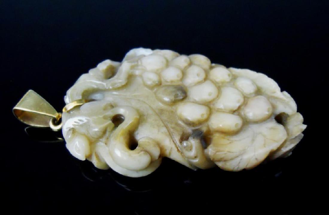 Antique Chinese Carved Jade Pendant: Chinese high quality antique carved white jade in bunch of grapes and leaf design. Jade with a 14K yellow gold suspension ring. Pendant measures: 2" L, total weight: 18.8 g. Provenance: From the colle