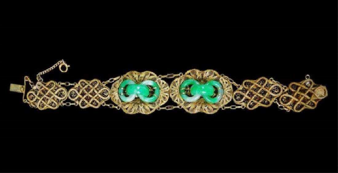 Chinese Vermeil and Jade Bracelet: Chinese bracelet crafted in linked gilded silver filigree adorned with white and green jade rings. Bracelet measures: 7.6" L, total weight: 21.4 g. Provenance: From the collection of Mrs. Winnie Davis