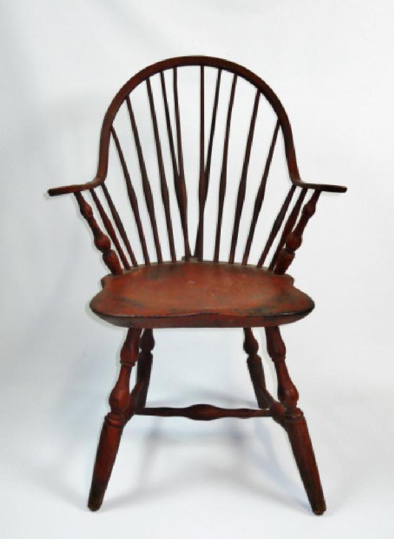 18th C. Primitive Windsor Armchair in Early Paint: 18th C. spindle back Windsor style armchair crafted in mixed woods with early russet red paint. Bent Hickory wood crest rail terminating at carved arms with carved pine board seat on vase turned leg a
