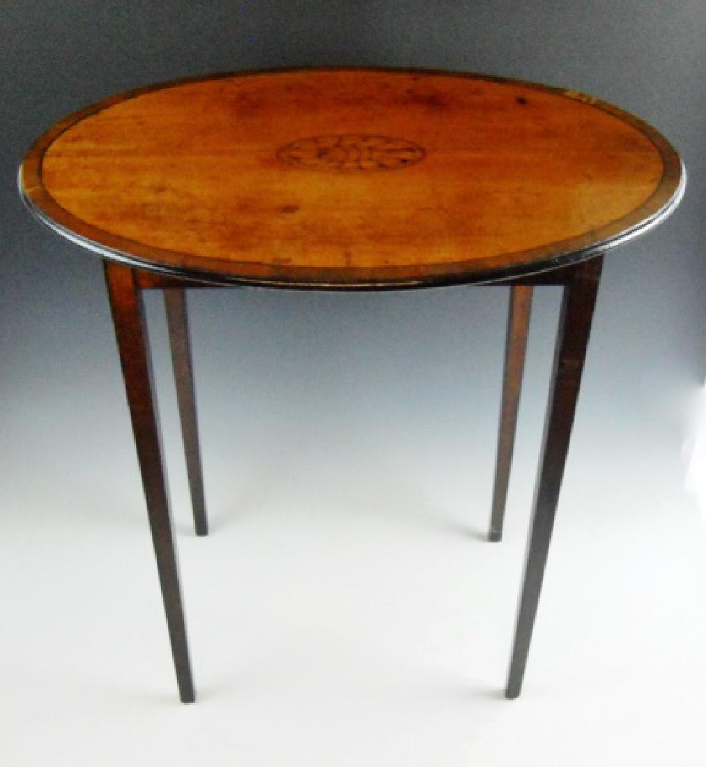 Federal Period Mahogany Tea Table: Circa 1800 American Federal tea table in mahogany. Table with banded oval top with inlaid satin wood shell decoration on elegantly tapered legs. Underside with blocks and signed "IM". Table measures: