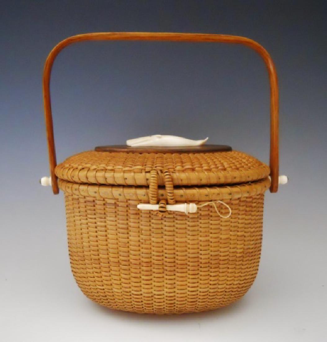 Vintage Nantucket Friendship Basket, N. P. G. 1967: Hand woven Nantucket Friendship Basket, signed on base, "N. P. G. 1967". Basket with carved whale, front pin closure and bent wood swing handle. Basket measures: 6.75" H x 9.25" W x 6.25" D.