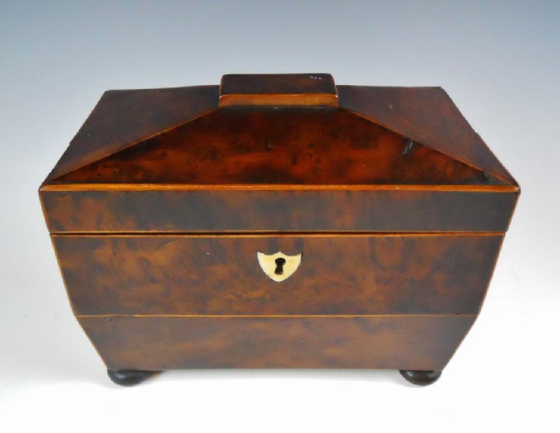 18th C. Walnut Burl Tea Caddy: 18th C. walnut burl lidded tea caddy. Coffin form with lock and bone shield form key escutcheon. Interior with two fitted compartments. Caddy on bun feet, (one missing), measures: 6" H x 7.5" W x 4.5"