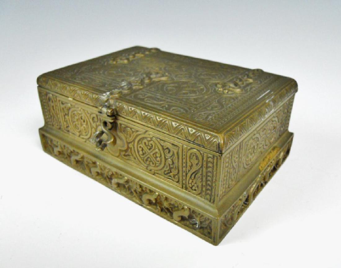 Antique Bronze Trinket Box, Tiffany Studios, NY: Antique cast bronze hinge lidded box with neo-gothic design. Box is wood lined and signed on base, "TIFFANY STUDIOS NEW YORK 1680" Box measures: 2.25" H x 5.5" W x 3.85" D.