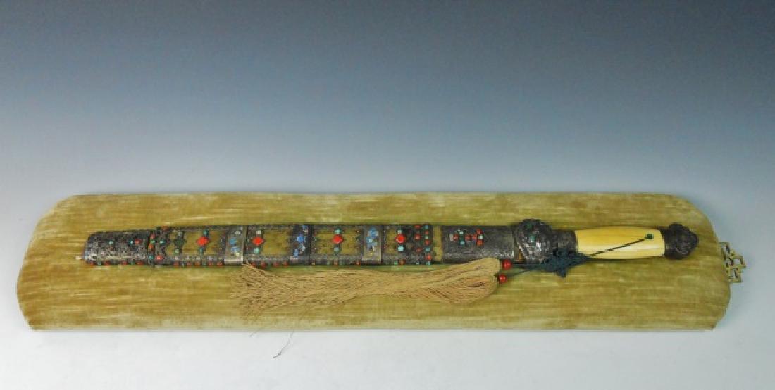 Chinese Ming Dynasty Silver Mounted Sword, 17th C.: Chinese 17th C. Ming Dynasty sword. Sword in Tibetan style with silver pommel and guard inlaid with semi-precious stones. Single edged blade with inlaid brass four character inscription, "Imperially m