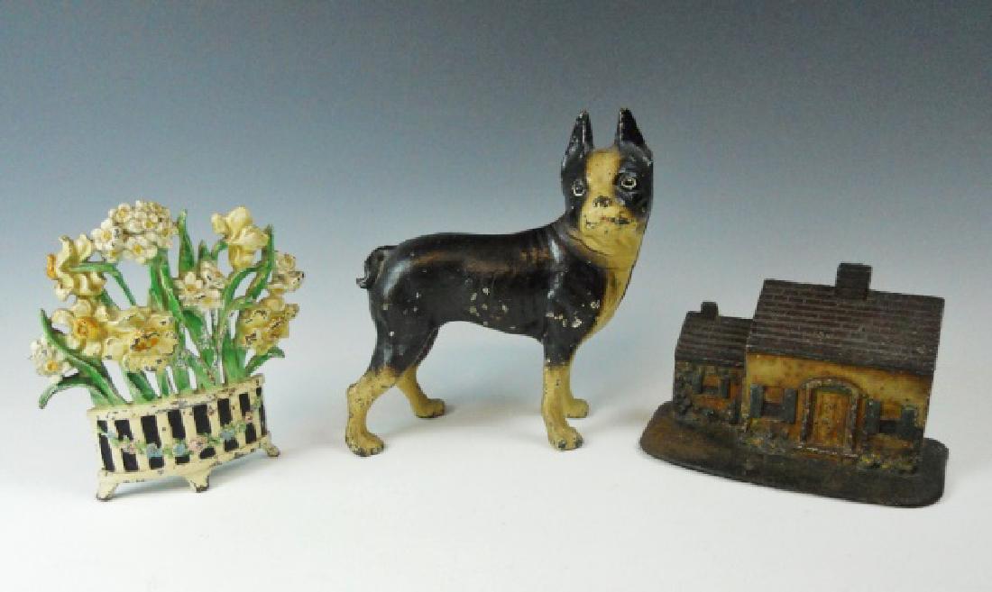 Collection of Antique Cast Iron Doorstops, (3pc): Collection of three antique cast iron doorstops: (1) Boston Terrier, (1) Cottage, (1) Flower Basket. All are original with period paint with wear consistent with age and use.