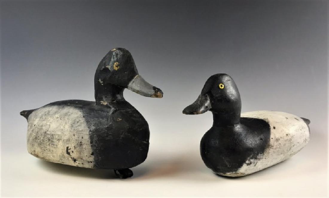 Hand carved, Painted Bluebill Duck Decoys, (2pc): Two eastern Massachusetts hand carved and painted bluebill duck decoys: (1) carved and painted glass eye bluebill decoy, excellent for, based with "S" brand. early paint, measures: 6" H x 13.75" L, (1