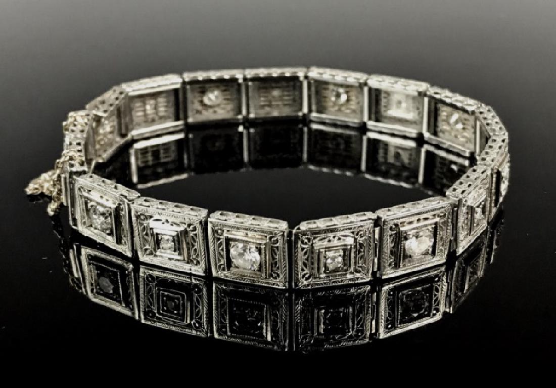14K Gold Filigree and Diamond Bracelet: Vintage 14K white gold link bracelet set with sixteen round cut diamonds in alternating sizes of approximately .2 Carat and .05 Carat stones. Each link decorated with filigree work, double latch clasp