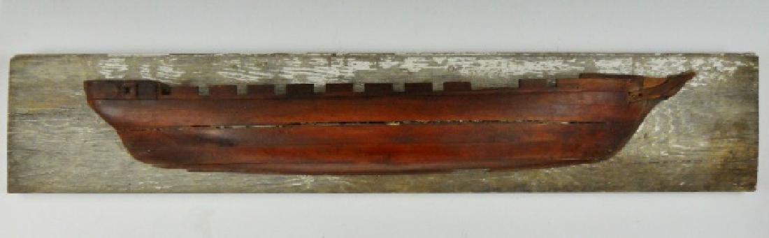 19th C. Primitive Carved Ship Builders Half Hull: 19th C. carved wood ship builder's half hull mounted to board. Model crafted in stacked carved wood with bow and stern carved detail. Measures: 7.25" H x 38.5" W on board. Hull measures: 31" L