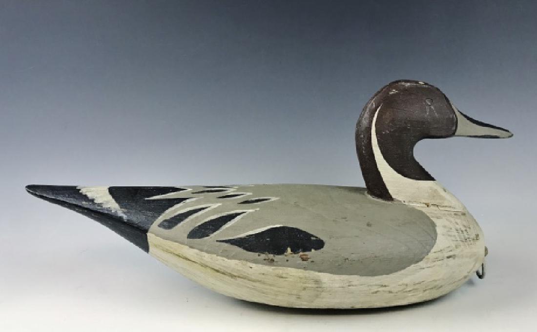 Two Carved Duck Decoys, Ron Vick (2pc): Two hand carved and painted Virginia duck decoys by Ron Vick : (1) Redhead decoy with original paint, rig loop and lead weight. Redhead measures: 8" H x 16" L(1) Pintail decoy with original paint, rig