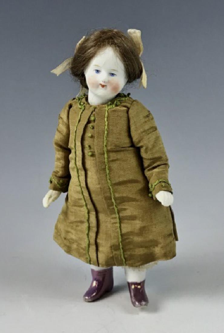 Early German Bisque Mignonette Doll 6": 19th C. German 6" socket head bisque mignonette doll with jointed arms and legs and natural hair wig. Face shows good color and detail. Boots are a mauve lustre glaze. Her costume is exquisitely detai
