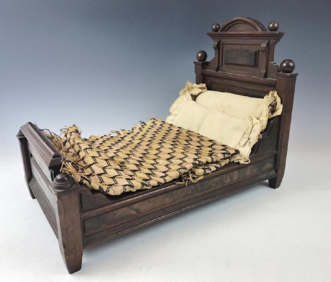 Antique Hand Made Empire Style Doll Bed, 1878: Hand crafted doll's bed with mattress and linens. Built of mahogany with burl inlay in the Empire style with turned cannonball finials. Bed with hand sewn mattress and four pillows, complete with wove