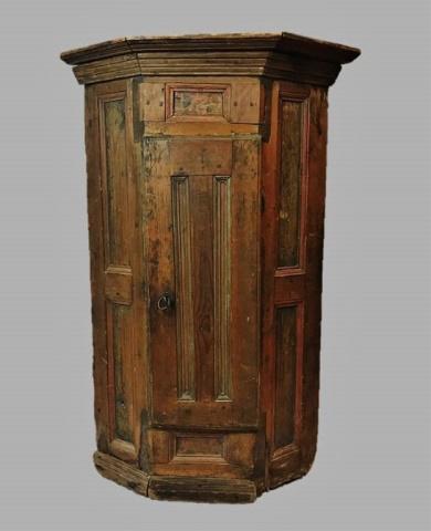 1789 Dated Pine Corner Cabinet: Primitive corner cupboard constructed of pine with remnants of period paint bearing 1789 date. Exterior with decorative moulding and chamfered panels Interior shelving with period lock and key. Measur
