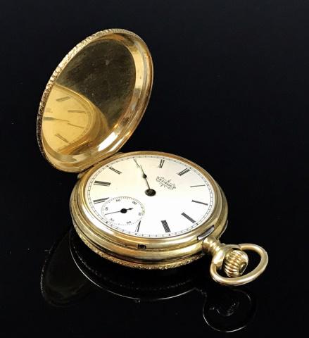 14K Gold Pocket Watch, Elgin National Watch Co: 1891 production pocket watch in 14K gold full hunter case with engraved foliate design. Stem wind porcelain face with Roman numeral radial dial with inset seconds dial. Three quarter gilt plate works