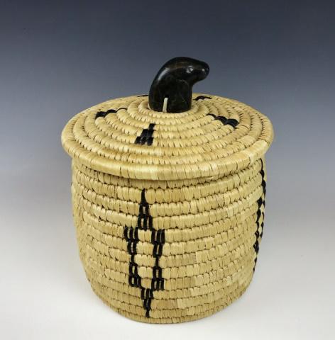 Native Inuit Woven Basket, Jeanie Inukpuk: Hand made Native Inuit woven basket, Attributed to artist, Jeannie Inukpuk. Lidded basket with seal skin decoration and carved soapstone figural finial. Measures:8" H x 8" D