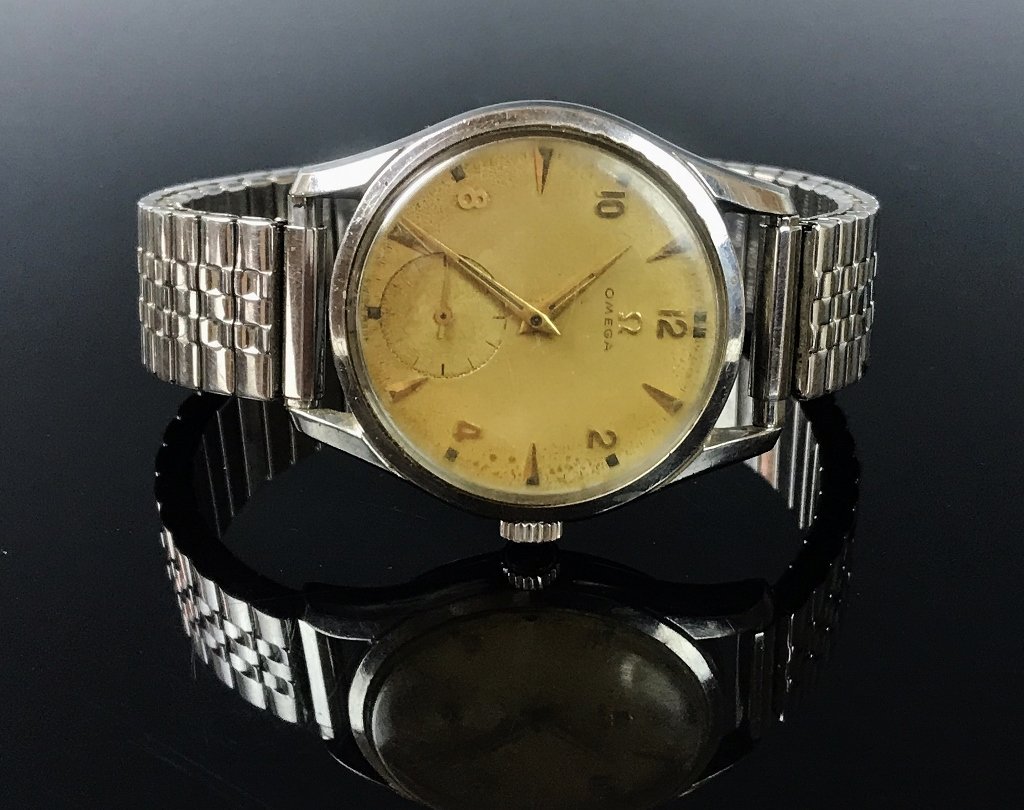 1950's Steel Bumper Case Omega Wristwatch: 1950's vintage men's steel bumper case wristwatch, face signed "OMEGA". Gold face with Arabic numeral and baton style radial dial, with gold hour and minute indicator hands, inset seconds dial. Band i