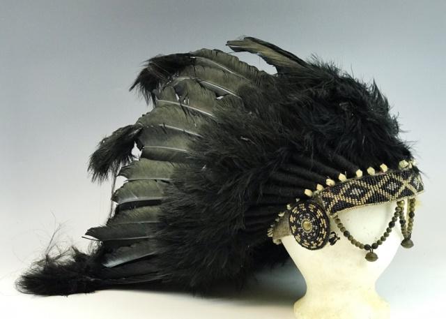Early 20th C. Northern Plains Indian War Bonnet: Circa 1920 Northern Plains Indian war bonnet. Black feathers arrayed on felt with detailed beadwork, with brass boss and bells. Measures:11" H x 15" W.