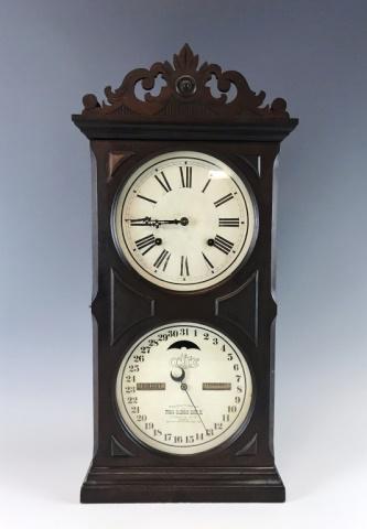 19th C. Clock, Ithaca Calendar Clock Co.: 19th C. mantel clock, "ITHACA CALENDAR CLOCK Co." Eight-day key wind movement, double dial mahogany case with carved crest. Clock face with Roman numeral radial dial with two winding ports, lower cale