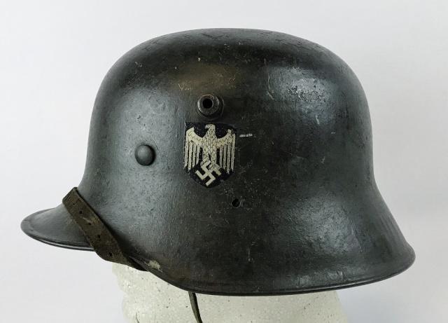 WW2 German Heer Single Decal Combat Helmet: World War Two German Heer M1918 Re-issue single decal combat helmet. Steel helmet with grey paint, rolled rim, ear holes, three split pins, black and silver shield eagle decal. Interior M1931 leather 