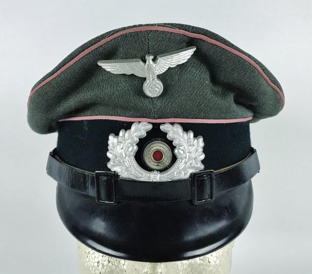 WW2 German Heer Panzer EM / NCO Visor Cap: World War Two German Heer Panzer EM / NCO visor cap. Green - grey wool construction with dark green band and pink piping, black lacquered vulcanfibre visor and black leather chinstrap secured by paint