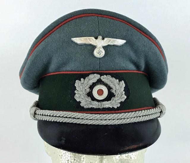 WW2 German Heer Artillery Officer Visor Cap: World War Two German Heer Artillery Officer visor cap. Quality blue - grey wool construction with dark green band, red piping, and black lacquered vulcanfibre visor. Braided silver bullion adjustable 