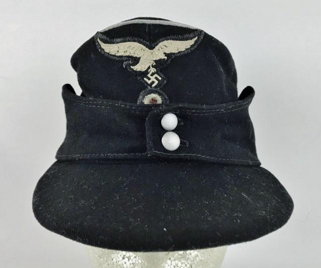WW2 German Luftwaffe Panzer Officer Field Cap: World War Two German Luftwaffe Hermann Goring Division Panzer Officer field cap. Black wool construction with braided silver bullion piping, ear flaps secured with two magnetic pebbled button. Two pie